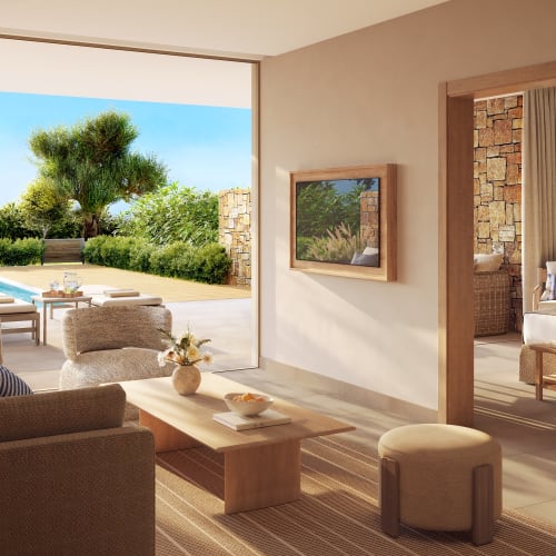 Luxuriöser Wohnbereich eines Bungalows mit großen Glasschiebtüren, die zu einem privaten Pool und einem üppigen Garten führen.