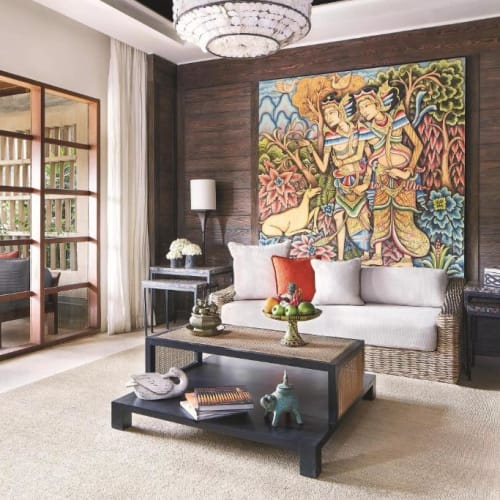 Elegantes Wohnzimmer mit weißem Sofa, dunklen Hölzern, buntem Kunstwerk und modernem Dekor.