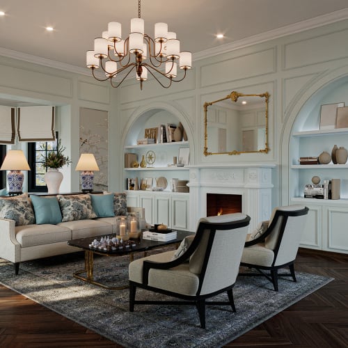 Elegantes Wohnzimmer mit einem beigen Sofa, zwei Sesseln, einem dunklen Glastisch auf einem strukturierten Teppich, eingebauten weißen Regalen mit Dekorationsgegenständen und einem beleuchteten Kamin unter einem goldgerahmten Spiegel.