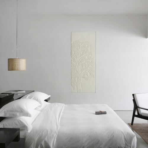 Ein minimalistisches Schlafzimmer mit einem weißen Bett, schwarzen Möbeln und einem kleinen Sitzbereich am Fenster in einem modernen Hotel.