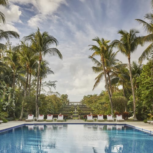 Luxuriöser Außenpool umgeben von Palmen in einem tropischen Resort auf den Bahamas.