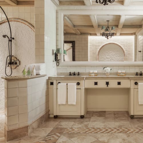 Luxurious bathroom with a double vanity, large mirror, and a separate walk-in shower with a rain showerhead.