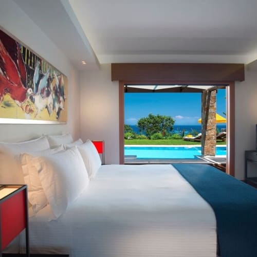 Luxuriöses Schlafzimmer mit Blick auf einen Pool und den Ozean in Griechenland