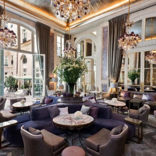 Luxuriöse Hotellobby mit eleganten Kronleuchtern, großen Fenstern und bequemen Sitzgelegenheiten.