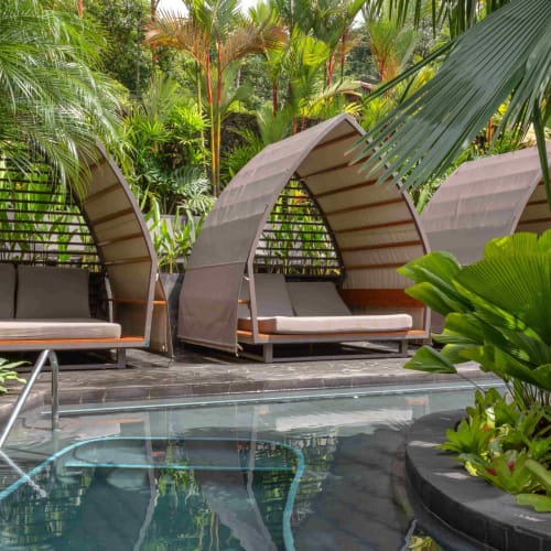 Luxurious outdoor pool area with modern cabanas surrounded by lush tropical greenery in Costa Rica.