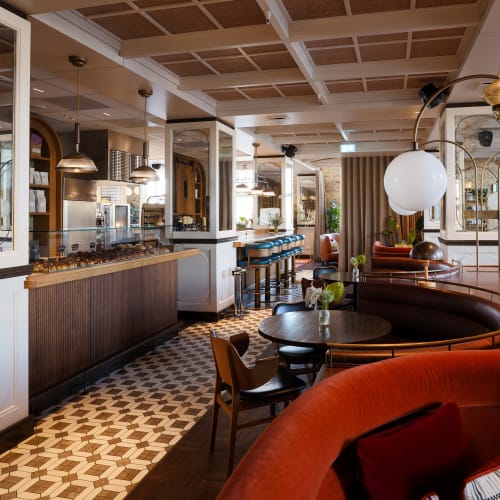 Elegant cafe interior with wooden ceiling panels, cozy seating, and modern lighting fixtures