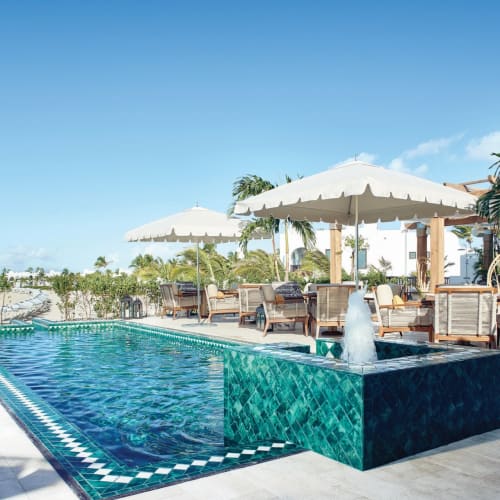 Außerhalb des Pools mit Sitz- und Sonnenschirmbereich in einem Luxusresort auf Anguilla.