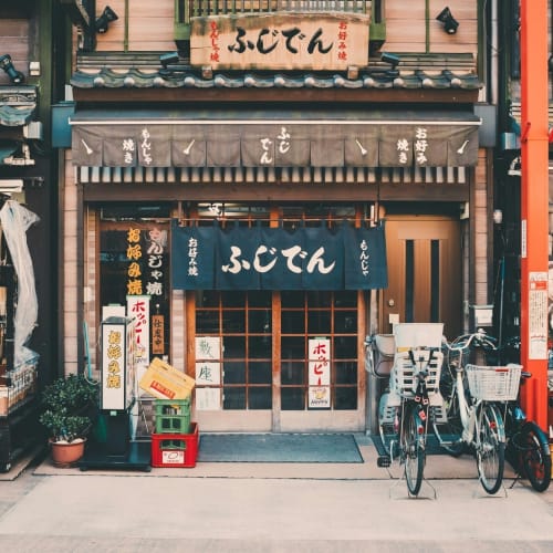 Traditional Japanese cafe with wooden sliding doors and bicycles parked outside in Tokyo.