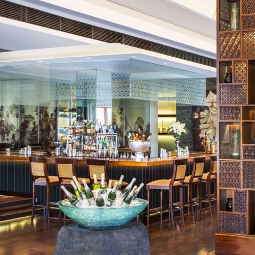 Elegantes Interieur der King Cole Bar im St. Regis Bali, mit zentralem Barbereich, bequemen Sitzgelegenheiten und dekorativen Regalen.