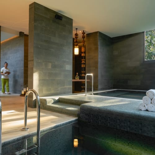 Innen-Hydrotherapie-Pool im Six Senses Krabey Island mit aufgerollten Handtüchern und modernem Dekor.