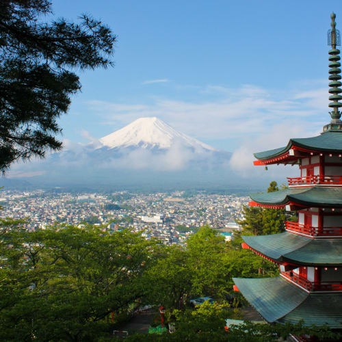 Eine traditionelle japanische Pagode mit dem Fuji im Hintergrund an einem klaren Tag.