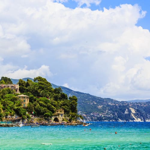 Ein malerischer Blick auf die Santa Margherita Bucht mit bunten Häusern an einem grünen Hügel und ruhigem türkisfarbenem Meer in Italien.