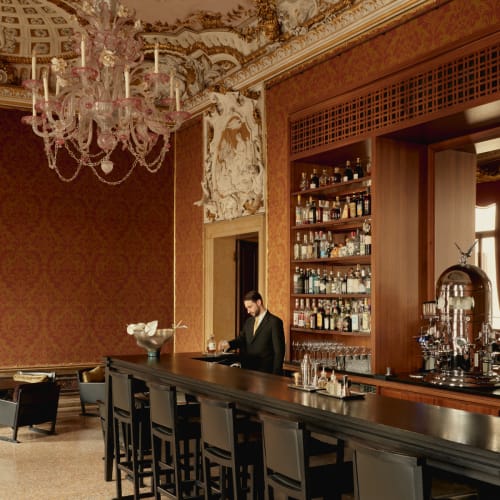 An elegant bar in a luxurious setting with ornate decorations and a chandelier hanging from the ceiling.