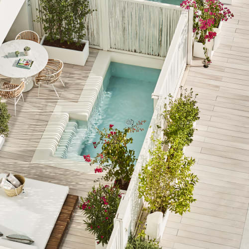 Ein Außenpoolbereich im Nobu Hotel Ibiza mit einem kleinen Pool, Sitzbereich und umgebender Begrünung.