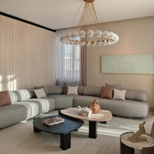 Elegantes Wohnzimmer mit einem großen, geschwungenen Sofa, zwei modernen Couchtischen und einer Topfpflanze in einem geräumigen, gut beleuchteten Raum.