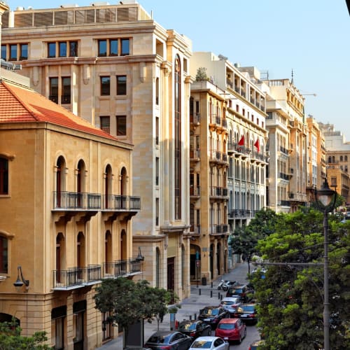 A view of a busy street in downtown Beirut with historic and modern buildings lining the street.