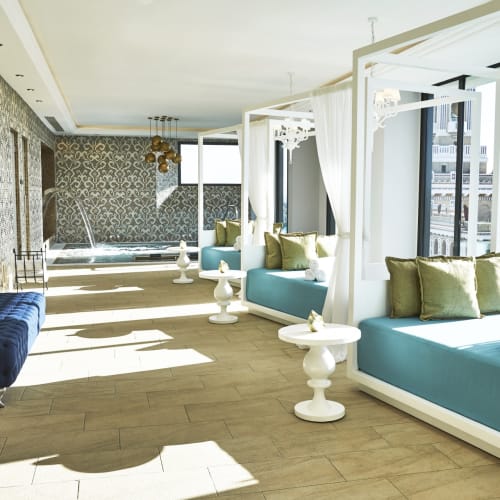 Luxusreicher Spa-Raum mit Liegesofas, eleganter Tapete und großen Fenstern, die natürliches Licht hineinlassen.