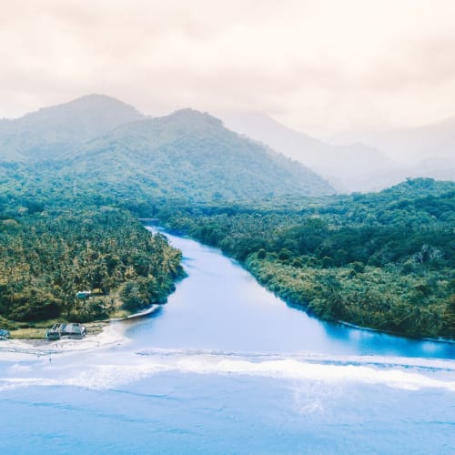A river flowing through a lush, green landscape with mountains in the background, possibly in Colombia.