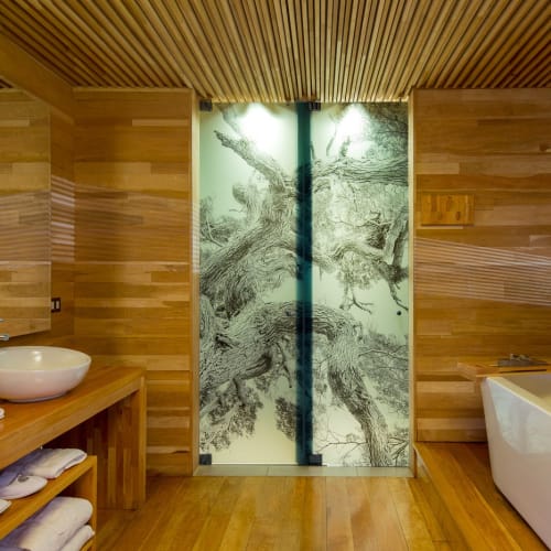 Modern bathroom with wooden walls, a large bathtub, and a glass shower with tree artwork.