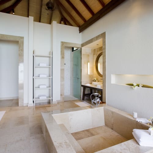Ein luxuriöses Wasser-Villa-Bad mit eingelassener Badewanne und modernem Design auf dem Malediven-Atoll.