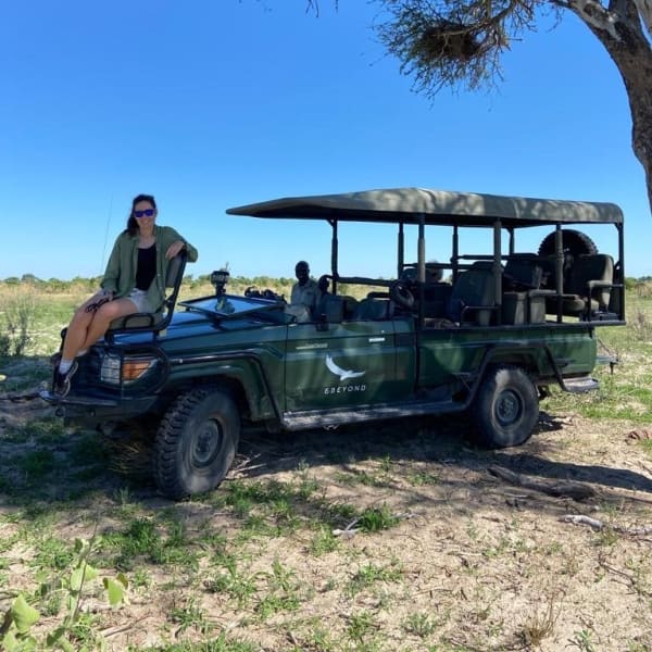 Eine Frau sitzt auf einem Safarifahrzeug