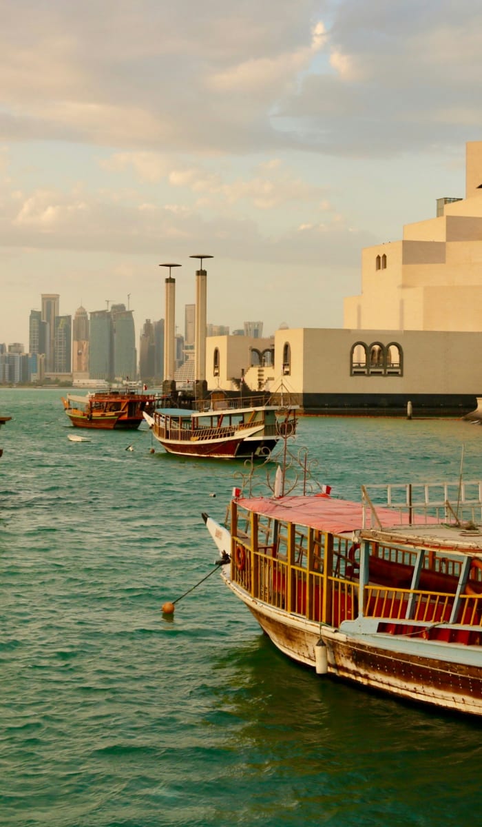 Boote treiben am Wasserufer von Doha mit Stadt skyline und moderner Architektur im Hintergrund.