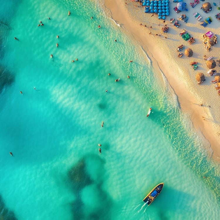 Luftaufnahme eines Strandes in Dubai mit türkisfarbenem Wasser, Schwimmern und Booten in der Nähe des Ufers.