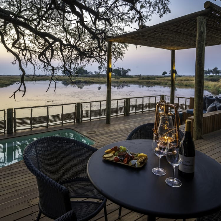 Privates Deck einer Safari-Suite mit Blick auf den Fluss, ausgestattet mit einem kleinen Pool, gemütlichen Sitzgelegenheiten und einer romantischen Abendstimmung.