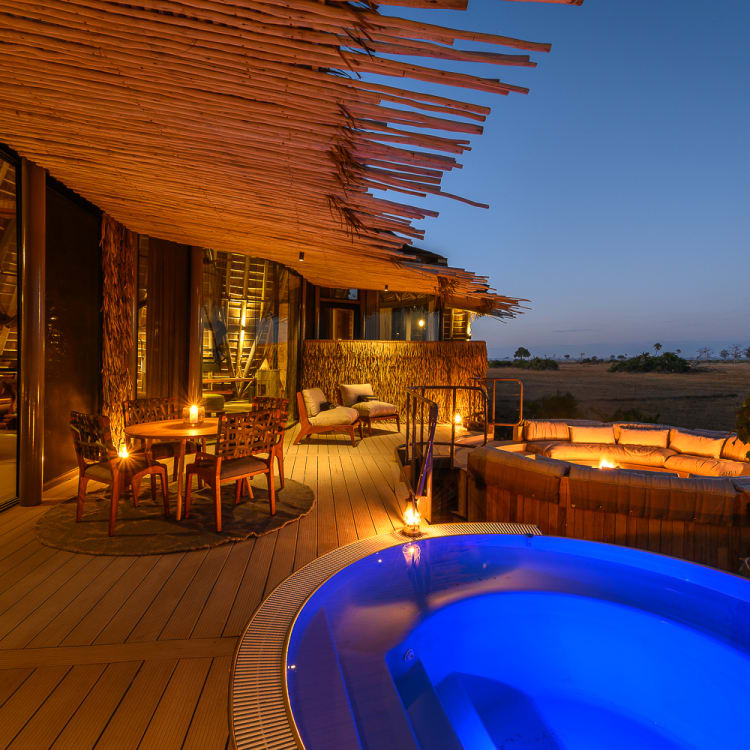 Stimmungsvolle Terrasse bei Dämmerung mit beleuchtetem Pool und gemütlichem Sitzbereich, perfekt für entspannte Abende unter dem Sternenhimmel