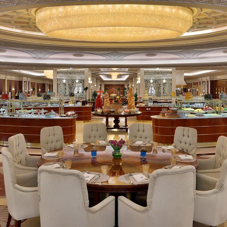 The restaurant of a hotel with a big round table under a chandelier