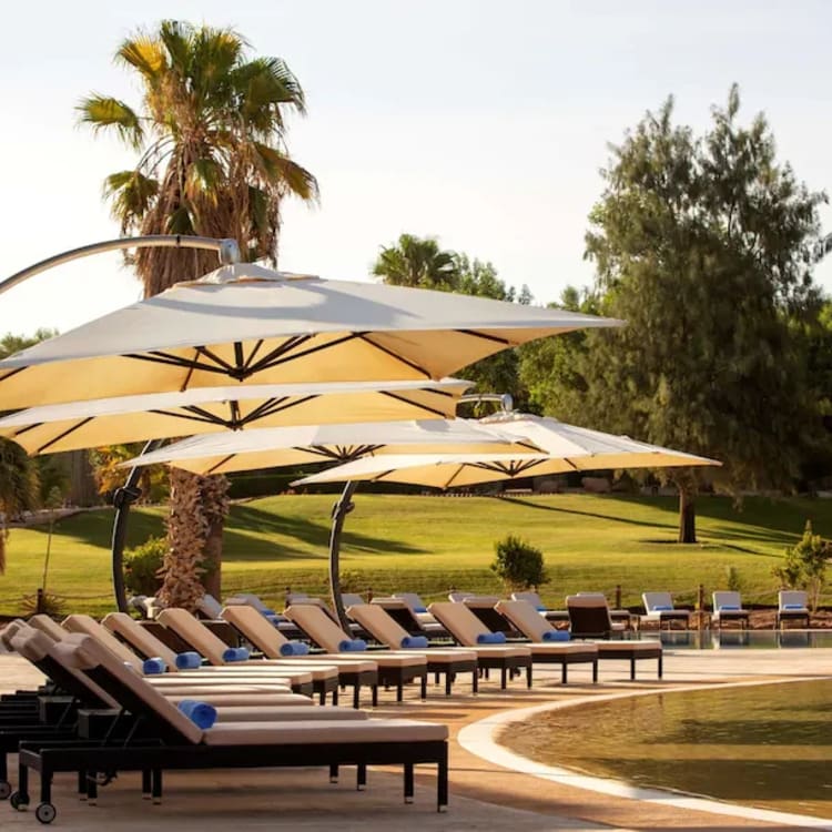 a pool area with lounge chairs and umbrellas