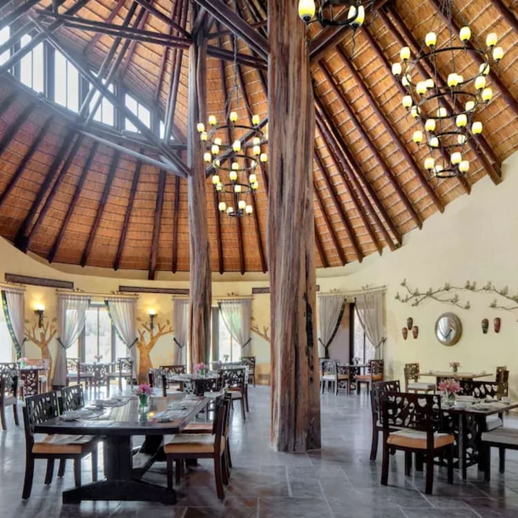 The restaurant of a hotel under a wooden dome with chandeliers