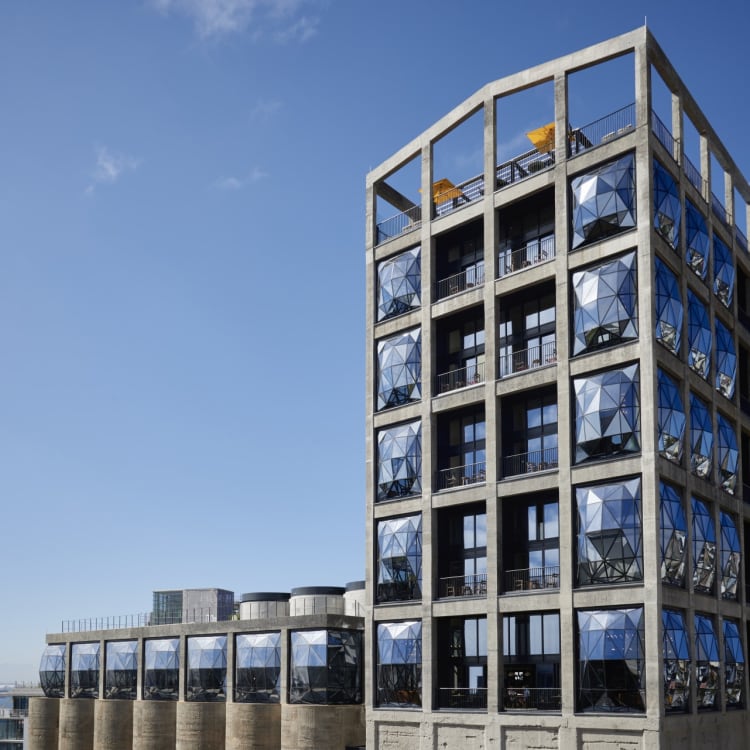 Modern high-rise building with geometric glass panels reflecting the sky in Cape Town, South Africa.