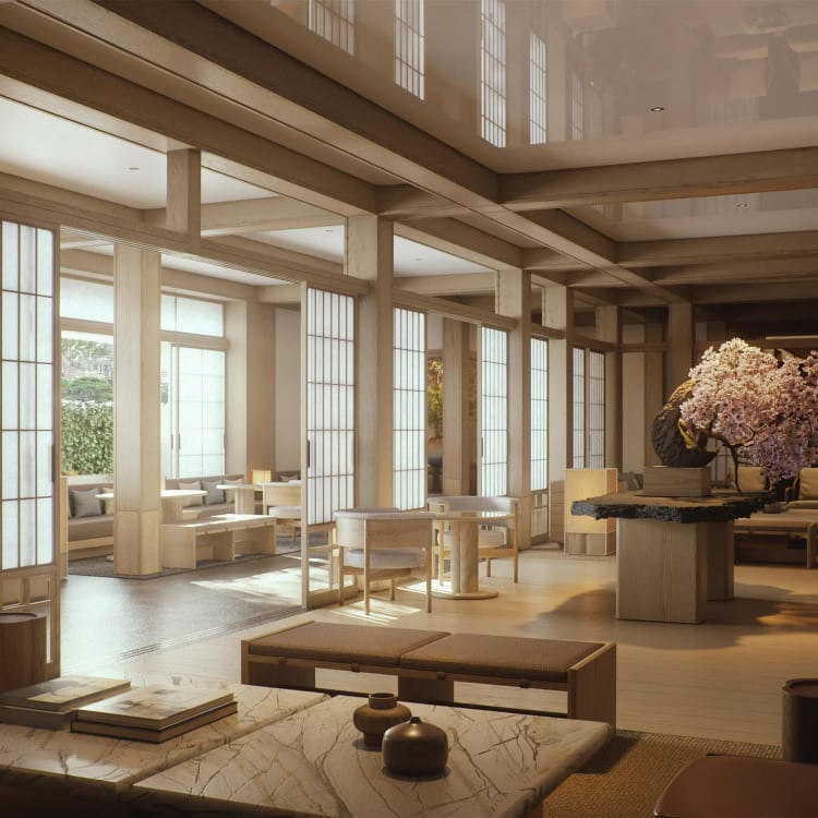 Innenraum eines geräumigen, gut beleuchteten Zimmers mit traditionellen japanischen Shoji-Schiebetüren, einer großen Blumenarrangements und modernen Möbeln.