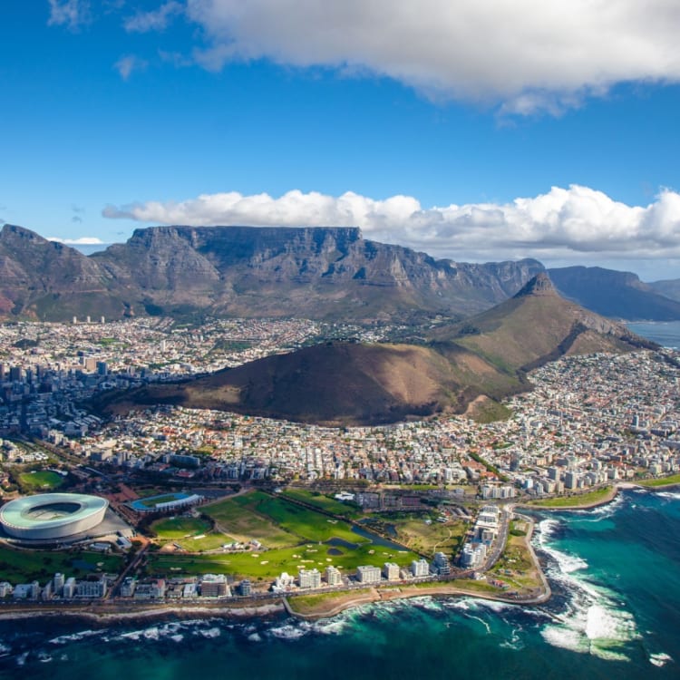 Aerial view of Cape Town with Table Mountain in the background, the city, and the coastline.