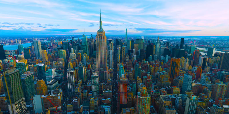 Luftaufnahme der New Yorker Skyline mit dem Empire State Building bei Sonnenuntergang.