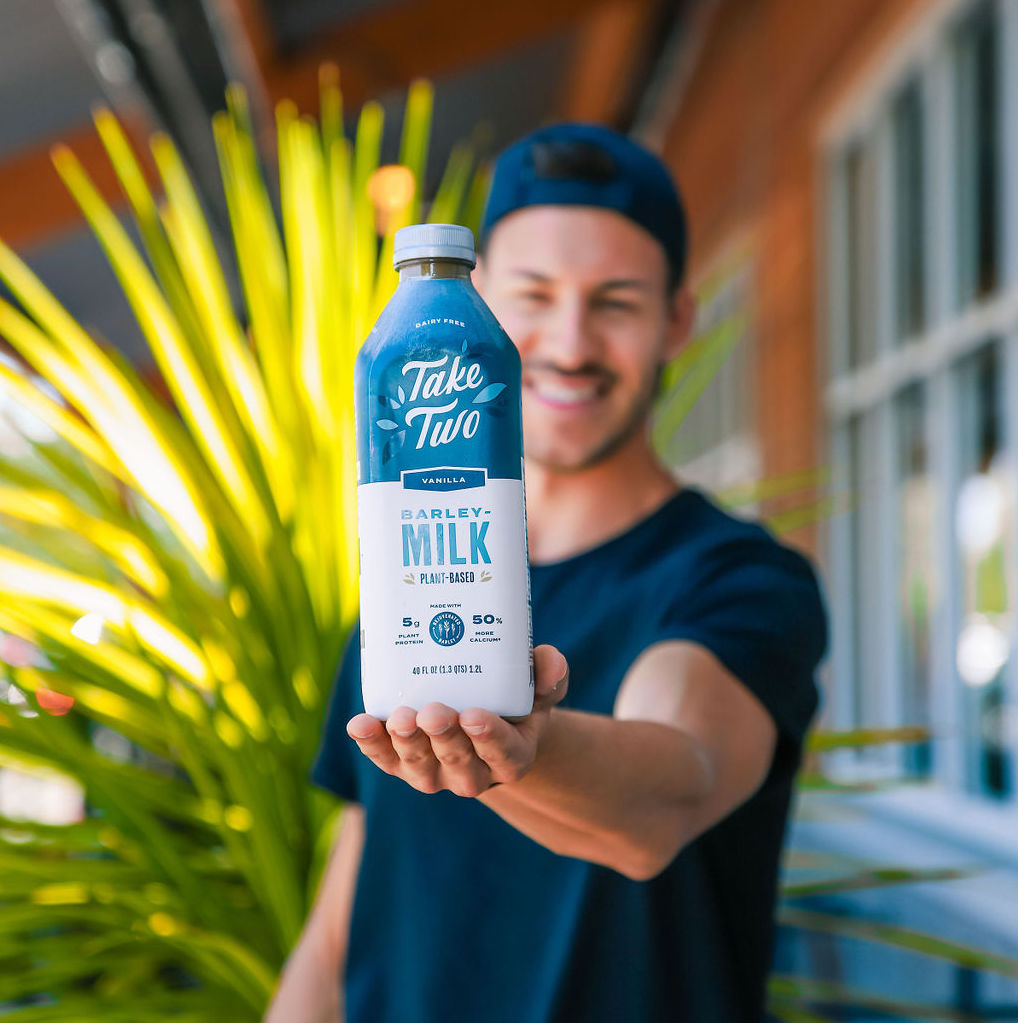 Man holding Take Two bottle.