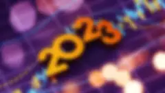 the numbers 2023 in golden orange on top of a purple background with hash marks and lens flares