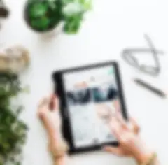 Mains décorées de façon ornementale explorant un site Internet sur une tablette