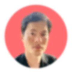 headshot of man of Asian descent with short dark hair and brown eyes, wearing a black suit jacket, on a circular coral background