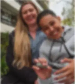 Mother and son smiling in front of an apartment building