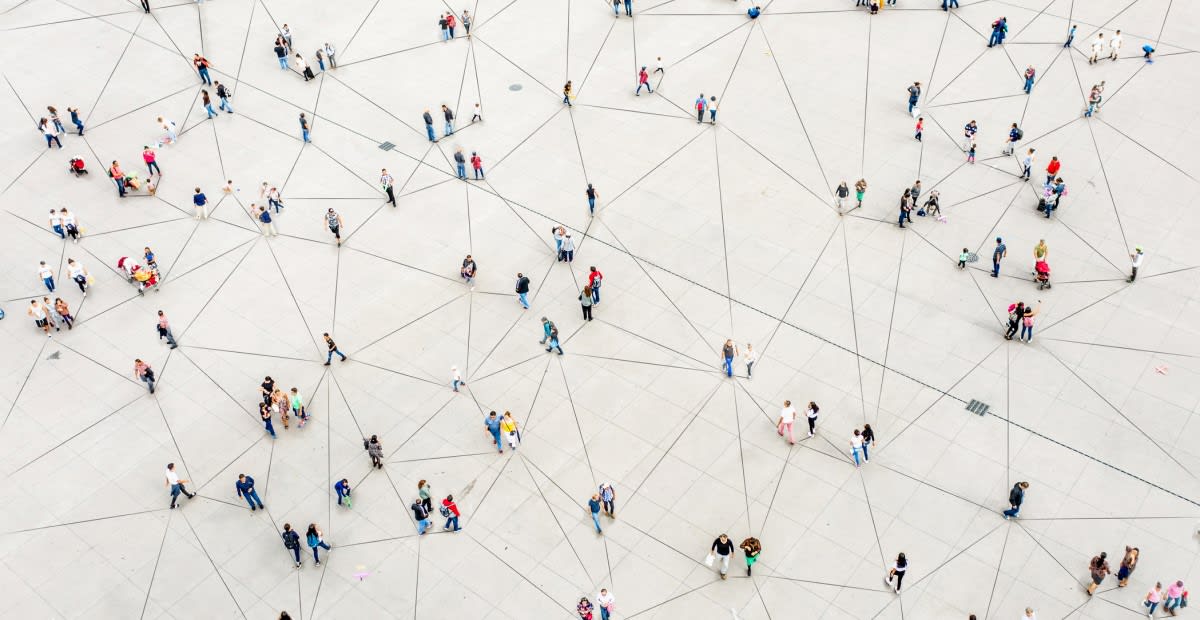 Arial photo of people standing at points of a web of connecting lines on the ground