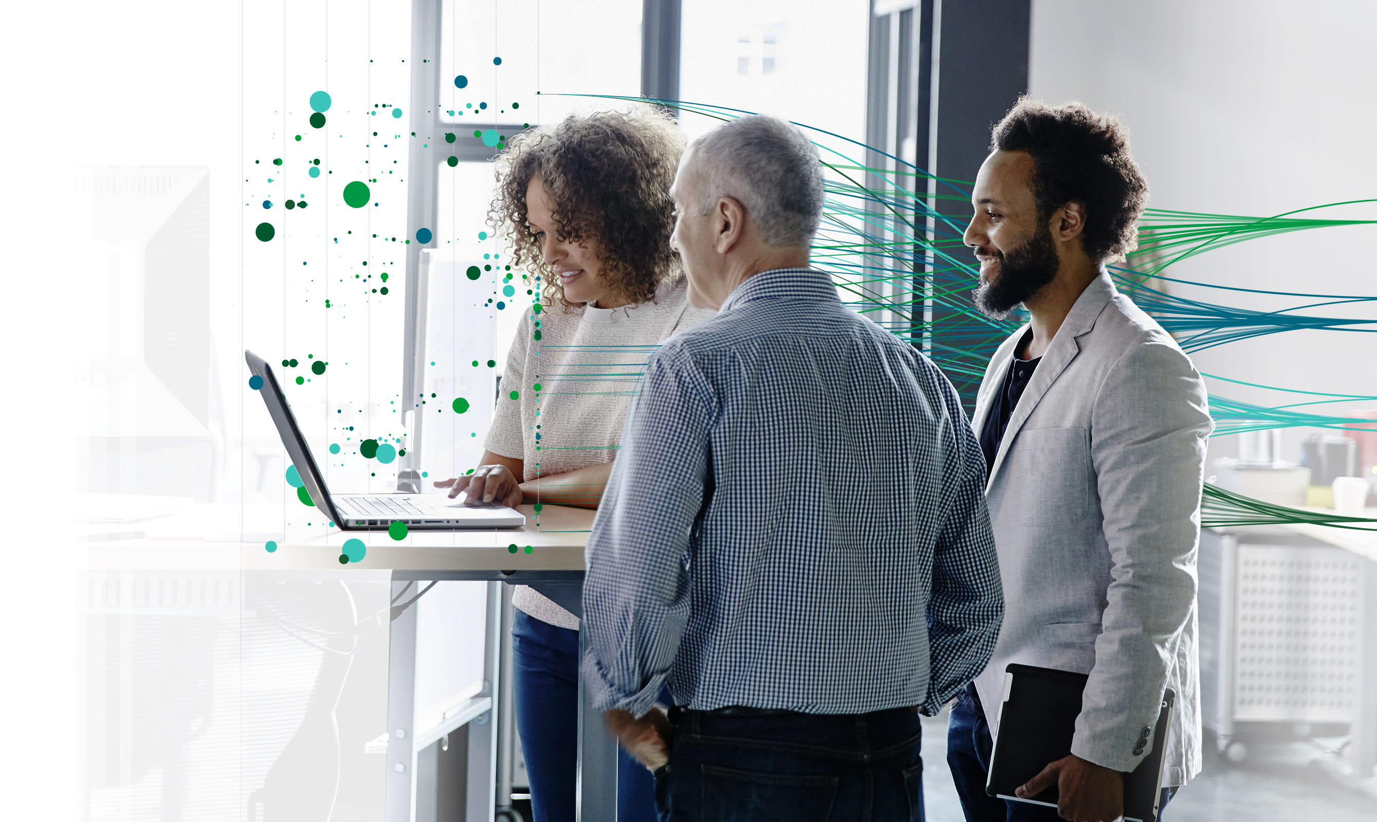 Three people stand around a laptop, engaged in discussion. Green and teal digital lines and dots superimposed in the background suggest technological themes.