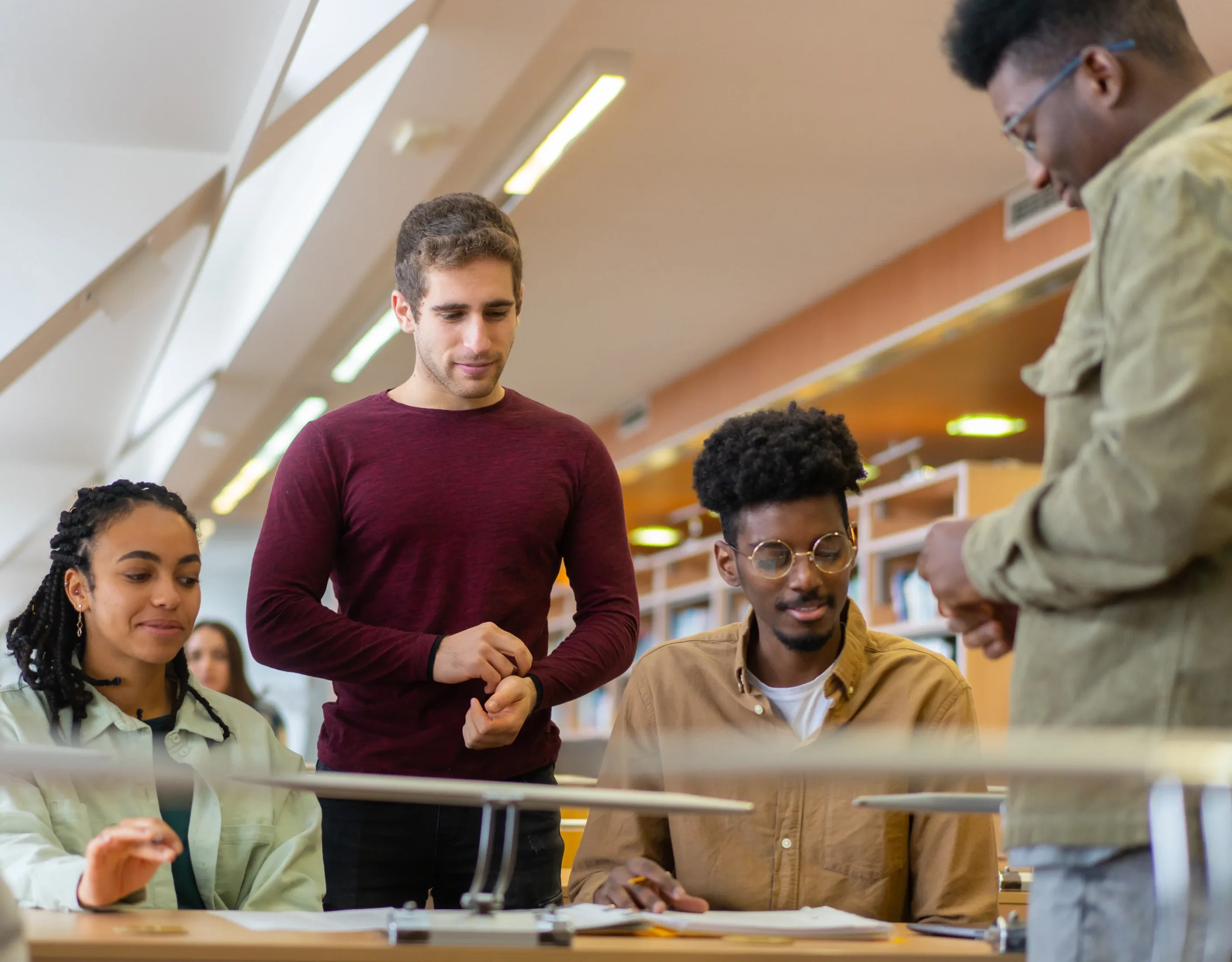 Diverse student group studying in a library as part of the Qlik academic program.