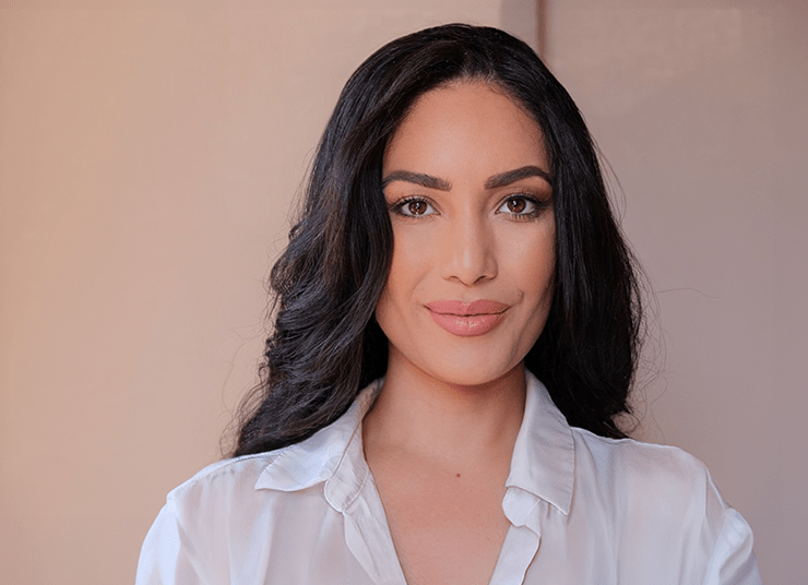 Headshot of Qlik AI Council member, Nina Shick. She has long dark hair and a slight smile, and is wearing a white collared shirt while standing in front of a neutral background.