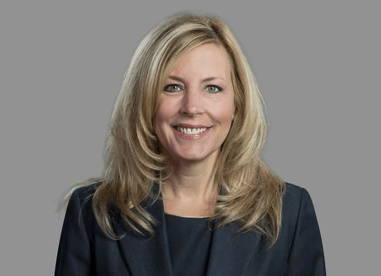 Headshot of Qlik Board of Directors member, DeLisa Alexander. She has long blonde hair, is wearing a dark blazer, and smiles in front of a plain grey background.