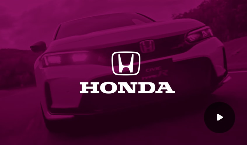 Honda company logo overlayed over the image of the front of a Honda car