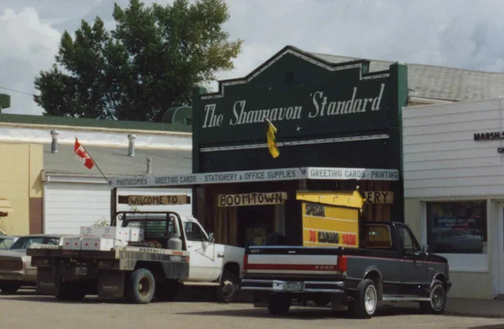 **August 1969**: The Shaunavon Standard Ltd. opens in this building — Herbert Sydney (Syd) Stevens and Jack Robertshaw are proprietors and editors of this local newspaper. They also sell business stationery, Moore business forms, wedding stationery, etc. **February 1977**: Jack Robertshaw is sole publisher of The Shaunavon Standard, after he purchases Syd Stevens’ share. **January 1984**: Robert J. and Leslie R. Irvine take over The Shaunavon Standard from Jack and Joan Robertshaw. **September 1987**: Front of The Shaunavon Standard building is redone. **October 1993**: Leslie Corrins (formerly Irvine) takes over as publisher of The Shaunavon Standard. Business sells stationery, paper goods, some computer supplies, greeting cards, fudge, and giftware.
