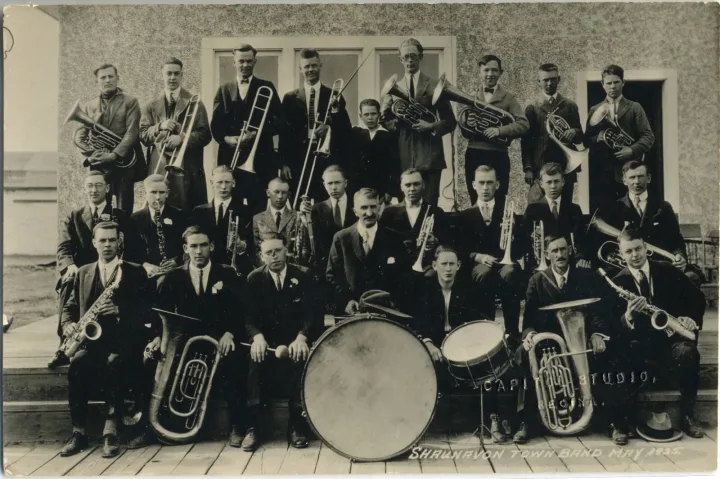 Shaunavon Town Band 1925 Back row: Melvin Webster, Art Edmunson, Tom Clark, Alway Bliss, Dillon Brady, Slim Barclay, Guy Mitchell, Mervyn Roe, Herbert Hipfner. Middle row: Frank Flude, Tommy Atkins, ?, Gordon Mackenzie, Alan M. Sanburn, A.J. Halsey, Homer Masten, Elliott Neese, F. Wilkinson. Front row: Givens Smith, Irving Hansen, Ralph Cudmore, bandmaster Thomas Ward, Bill Stedman, Archie Neese, Walter Edmunson