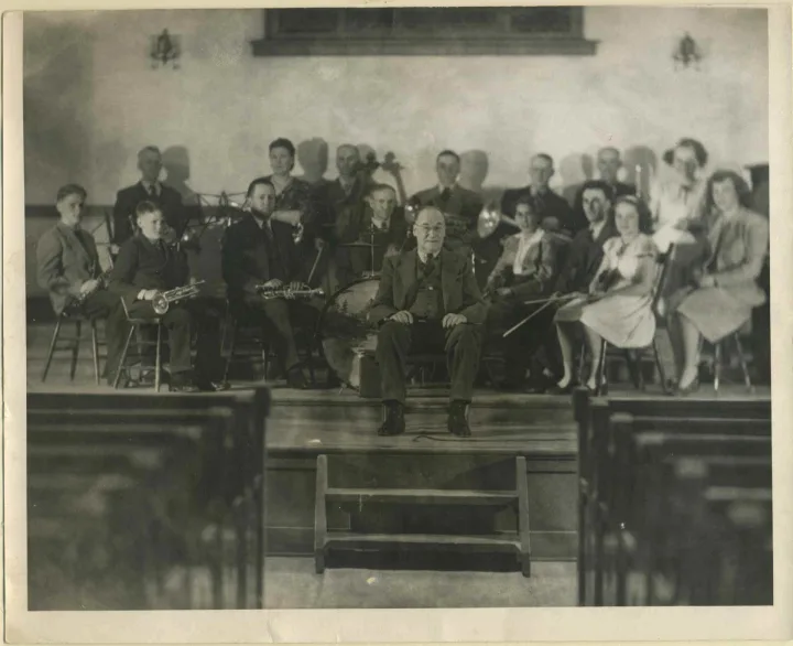 Shaunavon Band circa 1947 Back (l-r): Edgar Bowman (alto Horn), Mrs. Helme (euphonium), Arthur Mull (cello), Alex Jamieson (alto), Blake Todd (euphonium \[or tenor horn\]), Ernie Penlerick (trombone), ?\[Mrs. G.A. (May) Stevens (bass euphonium?\]. Seated (l-r): ?\[Donald\] Todd? (clarinet), ?\[Murray\] Todd? (cornet), Alex Sanburn (cornet), Lyman C. Whipple (drums), ?\[Edith\] Ross? (2nd violin), Marcel Vasseur (1st violin), Margaret \[or Muriel\] Jamieson (1st violin), Beryl Aldcorn (piano). Conductor - George Stevens.